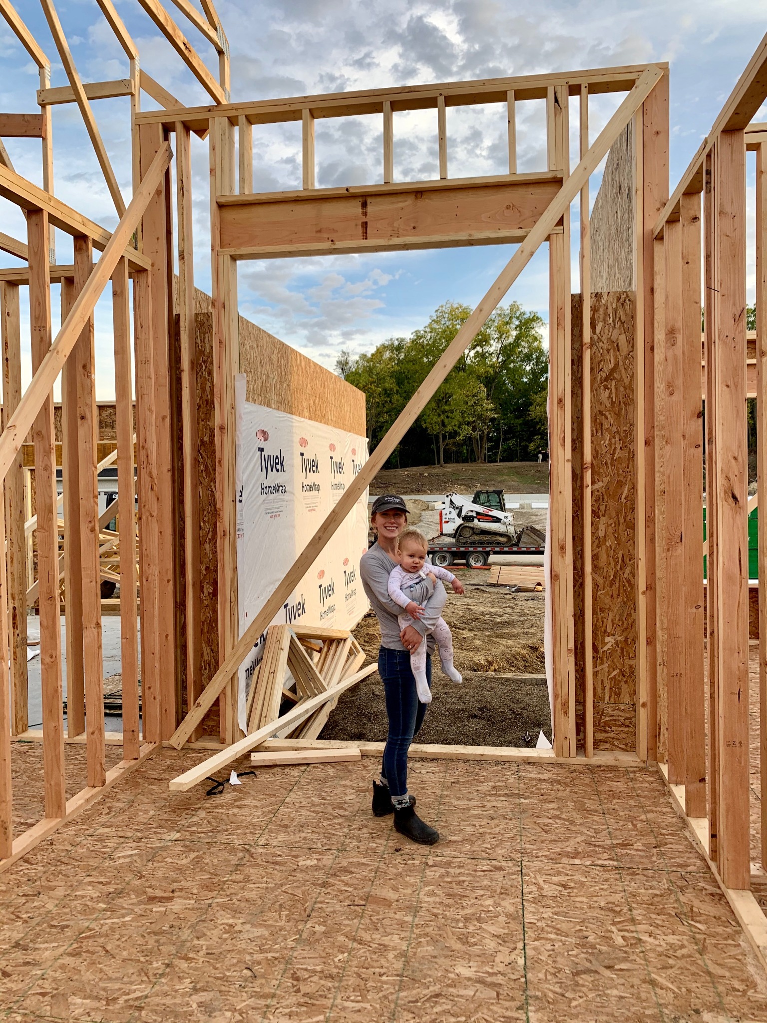 Lera Severtson with her son during the framing stage of a home